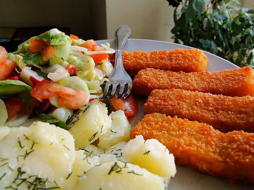Cod pané la cuptor cu cartofi copți și salată de varză, gata de servit