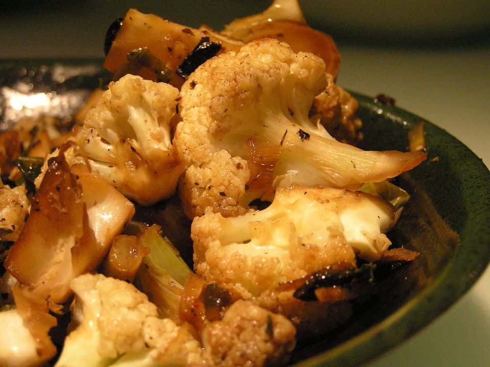 Conopidă coaptă cu năut crocant, tahini și rodie, gata de servit