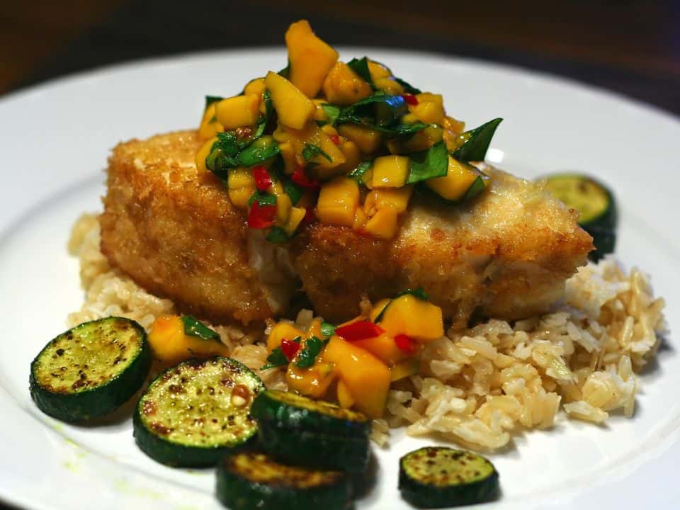 Tilapia la tigaie cu salsa de mango și avocado, cu orez brun, gata de servit