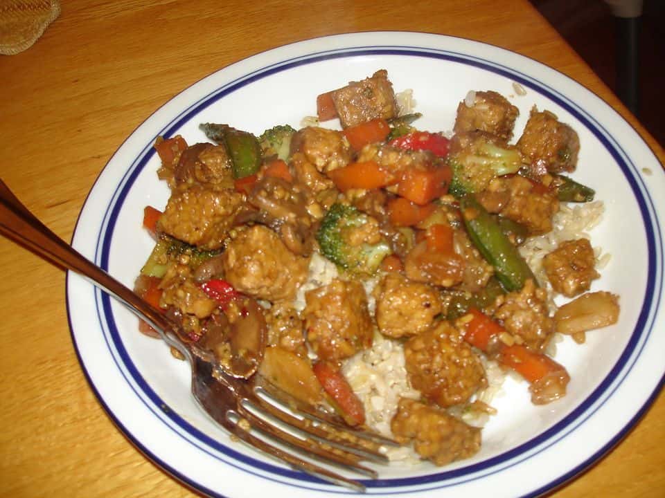 Tempeh la tigaie cu broccoli, ardei și tăiței de orez, gata de servit