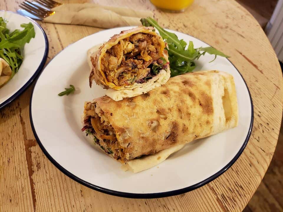 Wrap integral cu pui, hummus și legume crude, gata de servit
